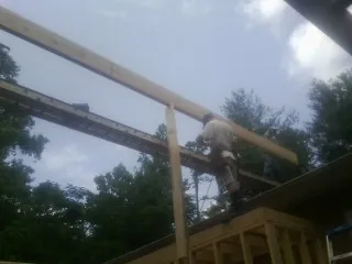 Carpenter setting a ridge beam over a new addition frame — Ice Dam Removal by Roofing Brothers in Eldorado Springs