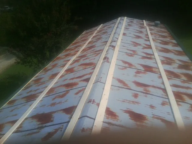 Rusted metal roof panels with new wood purlins before replacement — Storm Damage Roof Repair in Eldorado Springs by Roofing Brothers