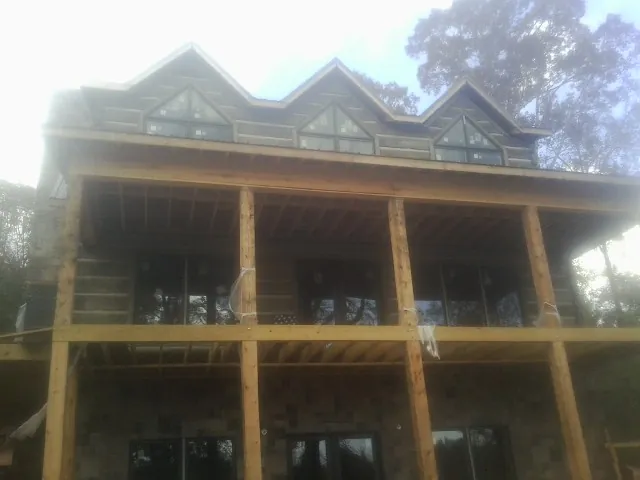 Dormers and porch framing on a large log home under construction — Roof Coating work by our crew in Eldorado Springs
