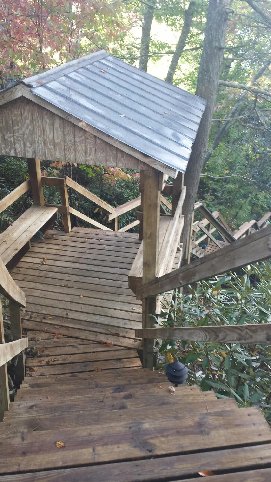 Metal roofed shelter over wooden steps on a wooded walkway — Skylight Repair & Installation work by our crew in Eldorado Springs