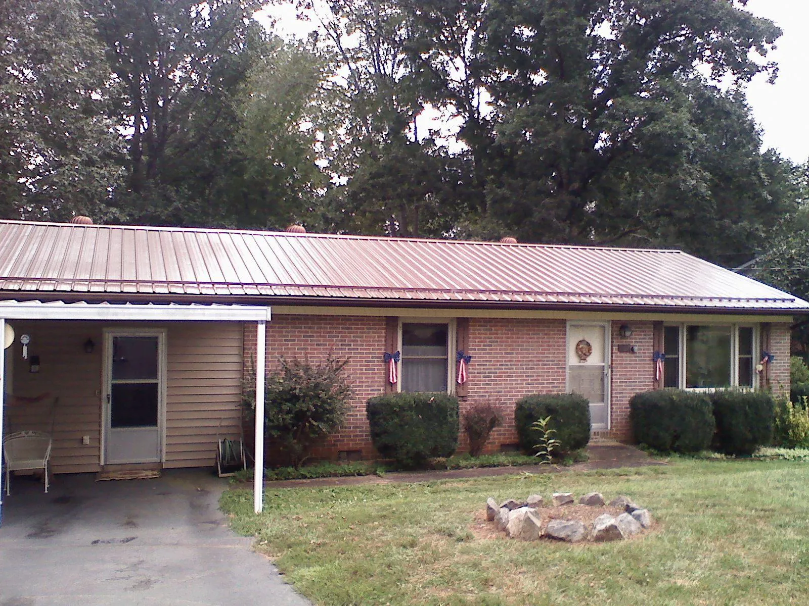 Bronze metal roof and carport on a brick ranch home — Roof Repair work by our crew in Eldorado Springs